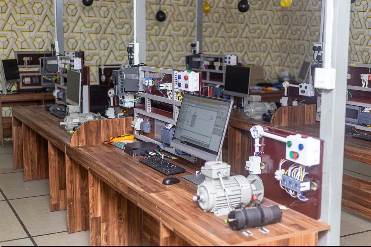 Automation training lab with PLC trainer panels, motors and computer workstations