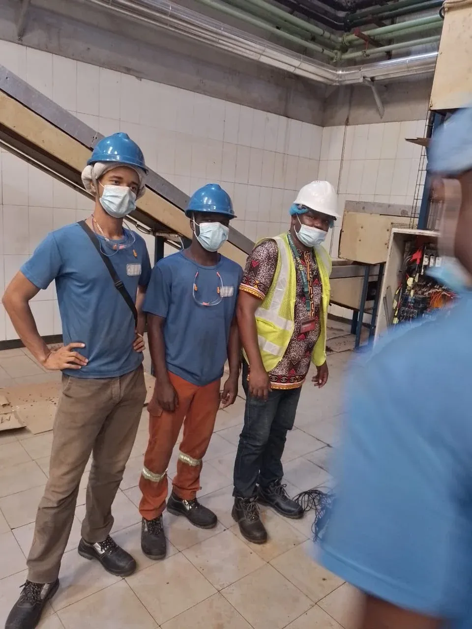Remotec engineer and client technicians in hard hats beside a motor control panel
